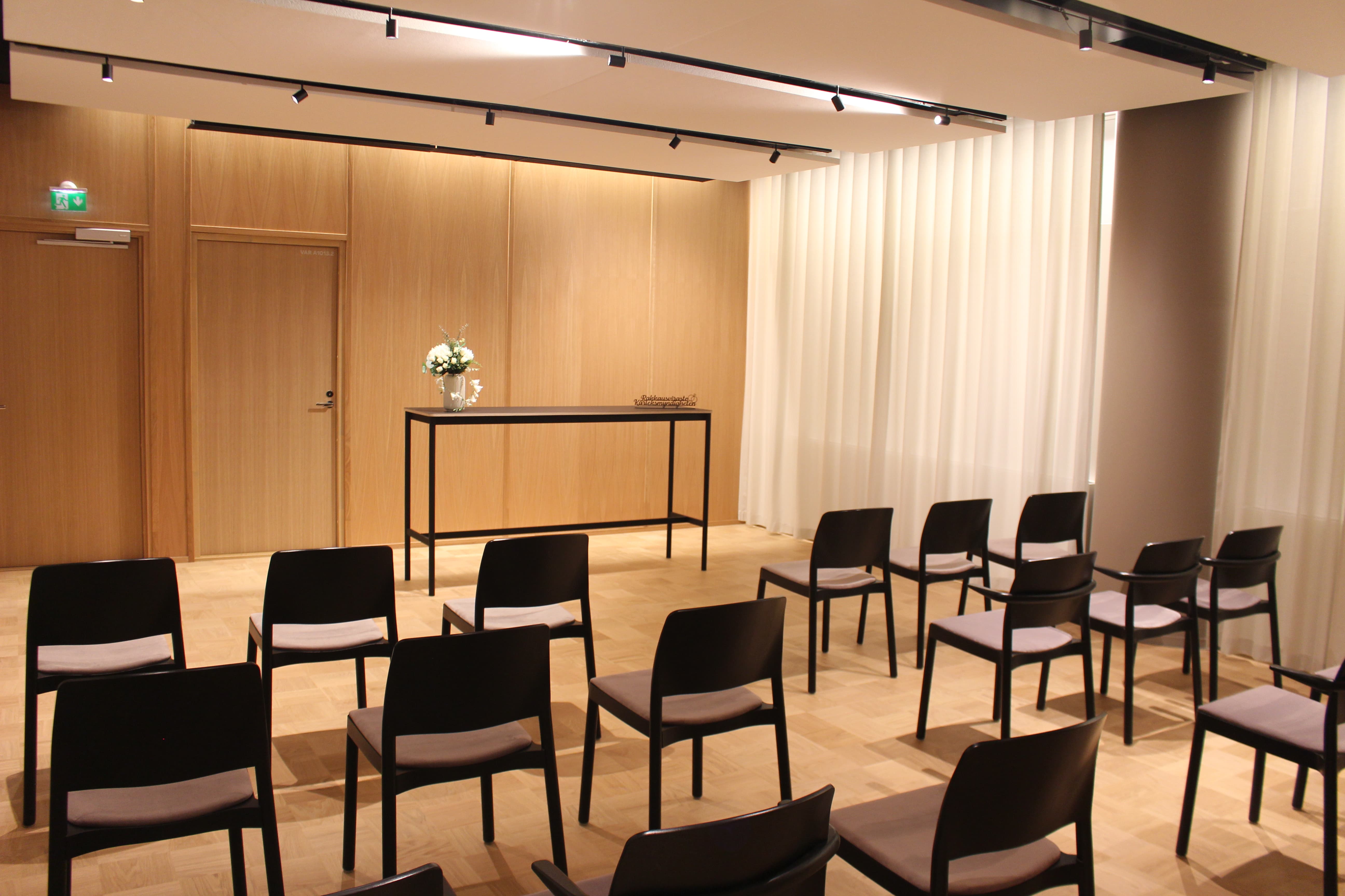 A warmly lit room with chairs and a flower on the table.