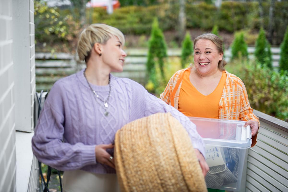 Two people are carrying moving boxes.