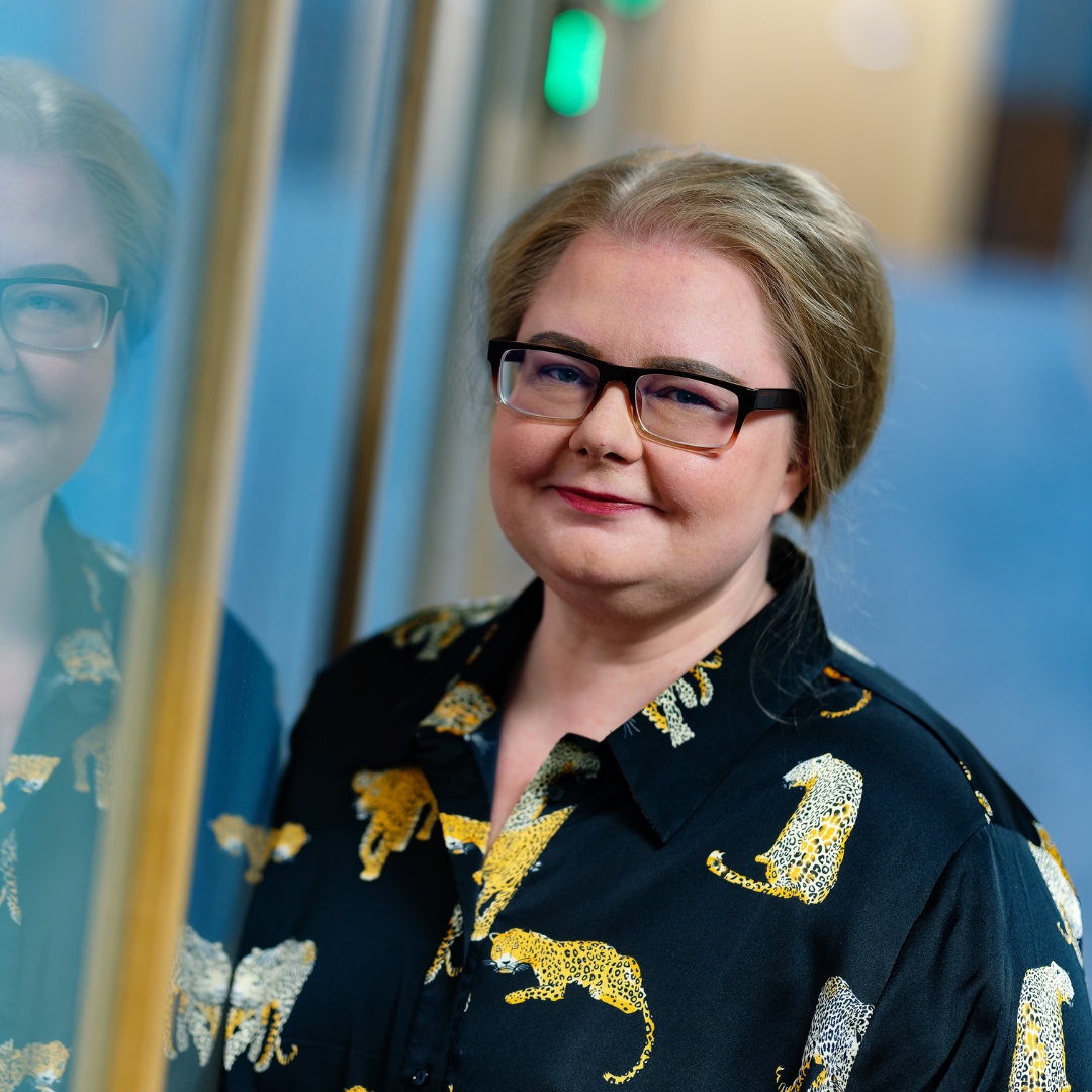 Rosa toimiston käytävällä tummassa eläinkuvioidussa paidassa